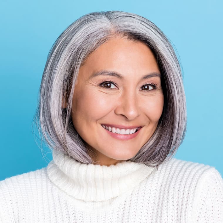 Headshot of older asian woman on blue background