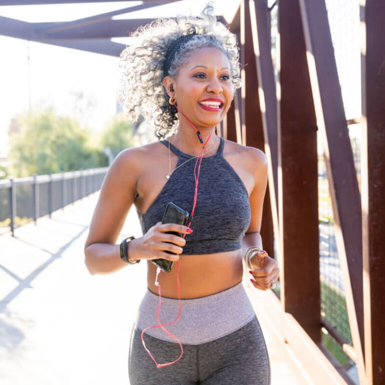 Beautiful black woman running on a bridge