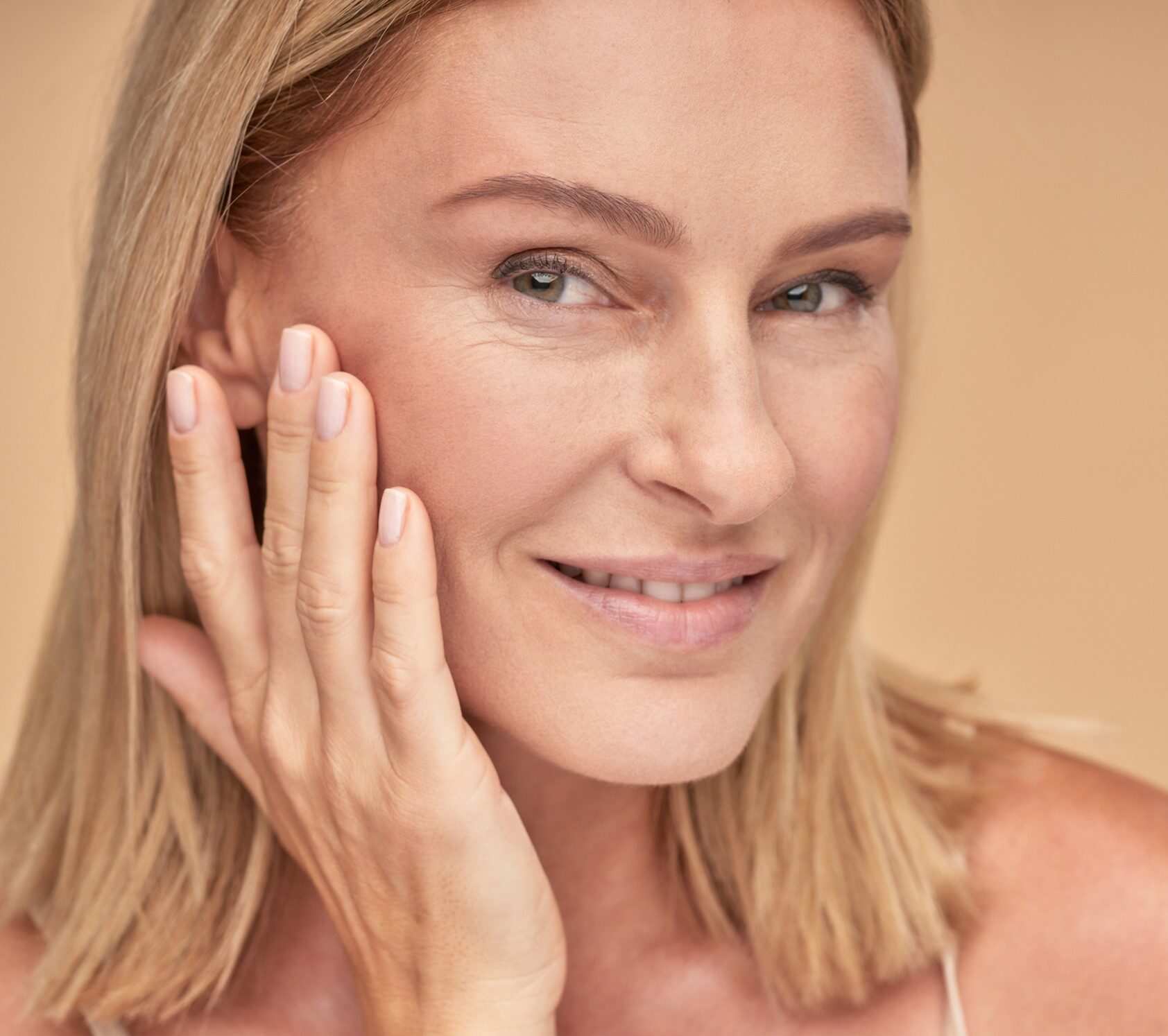A woman touching her cheeks showing the results of wrinkle treatment in Winter Park, FL